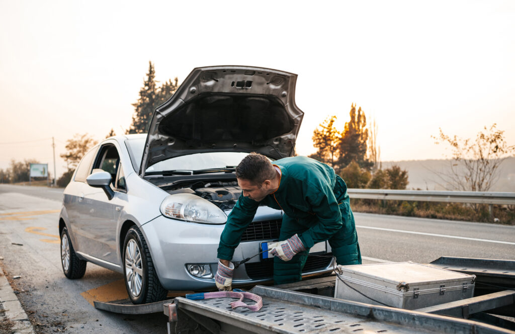 Roadside technician preparing a vehicle for safe towing