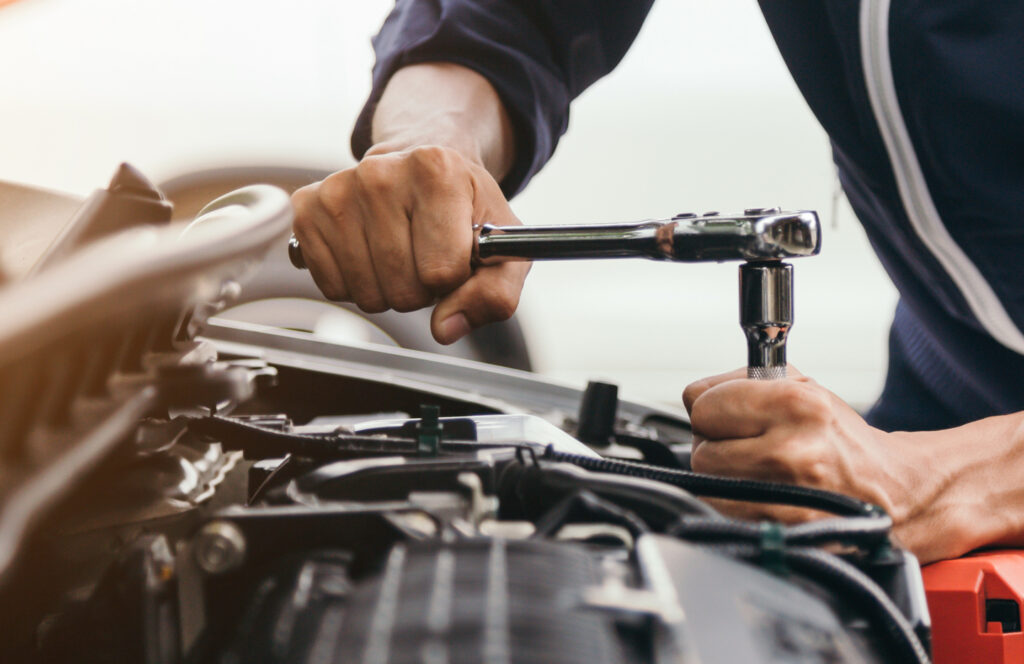Technician using a torque wrench in a vehicle engine bay